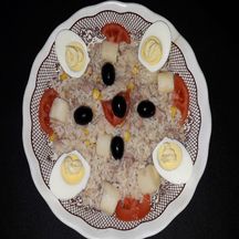 Salade de riz, cœurs de palmier, thon, maïs, olives noires et œufs durs.